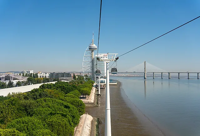 View from the cable car over the Tagus riverbank, with the Vasco da Gama Tower and the Vasco da Gama Bridge in the distance